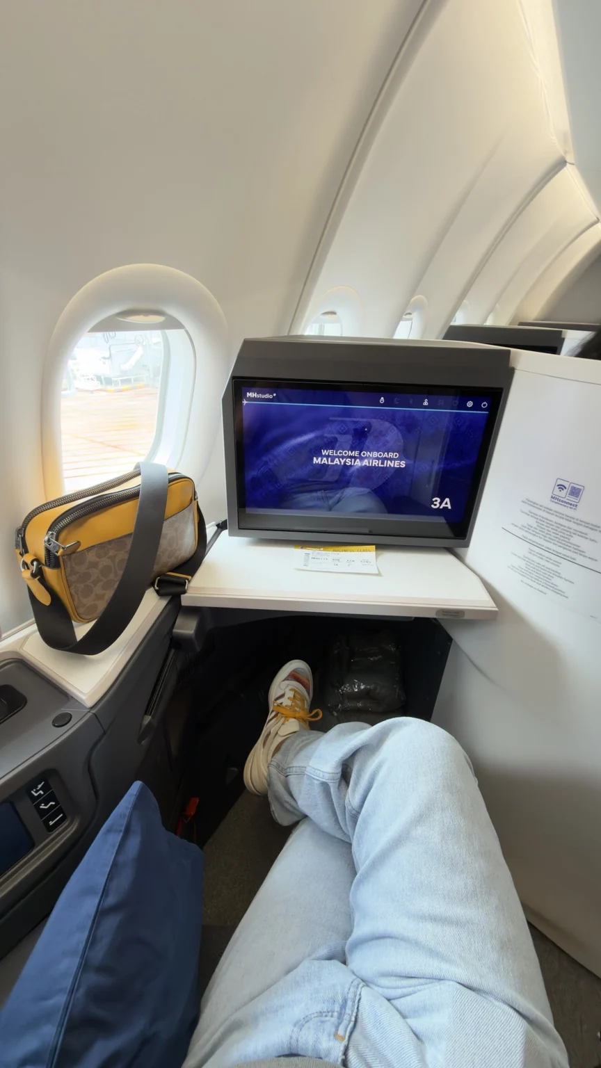 A window-side Business Class seat on Malaysia Airlines.
